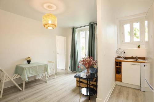 une cuisine et une salle à manger avec une table dans l'établissement Appartement au centre ville avec mini jardin charmante, à Montgeron