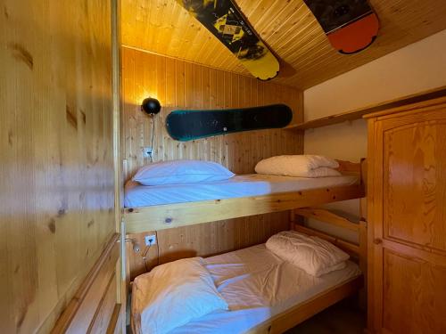 a room with two bunk beds in a cabin at Homency - Résidence les Chanses E3 in L'Alpe-d'Huez