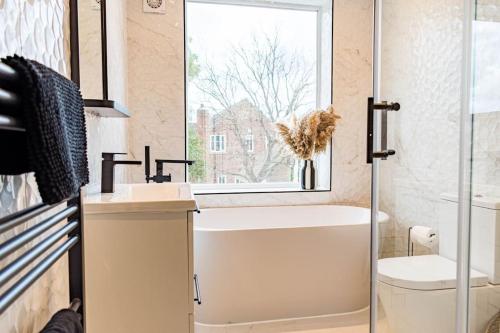a bathroom with a tub and a sink and a window at Roseberry - Corner Plot Getaways in Stockton-on-Tees