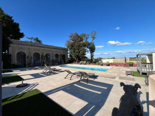 une piscine avec une statue de chien devant un bâtiment dans l'établissement Château de Briante, à Saint-Lager