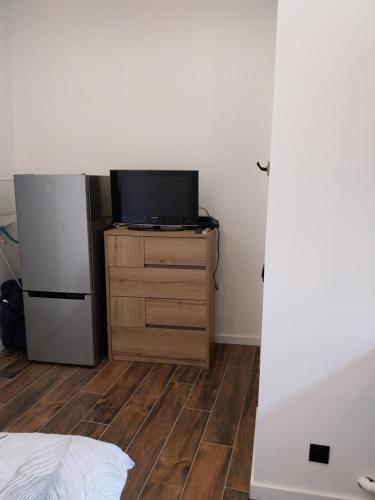 Cette chambre dispose d'un réfrigérateur et d'une télévision sur une commode. dans l'établissement Studio hypercentre, refait à neuf, à Aubagne