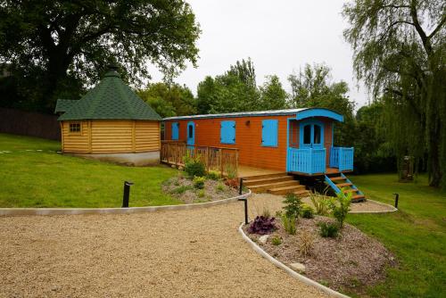 a small house with a playground in a yard at Roulottes et son kota grill sauna in Bucilly