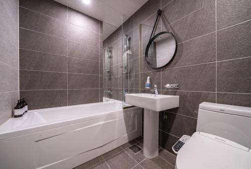 a bathroom with a sink toilet and a mirror at Hotel French code Myeongji in Busan