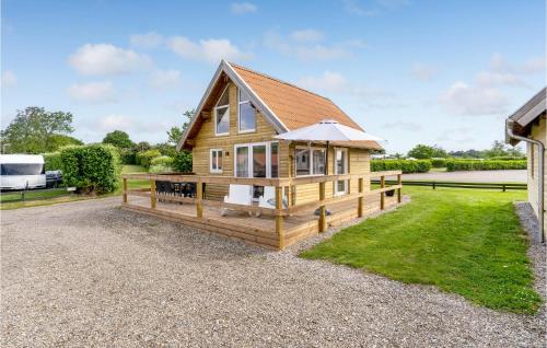 a cabin with a large deck and a house at Gorgeous Home In Tranekær in Tranekær