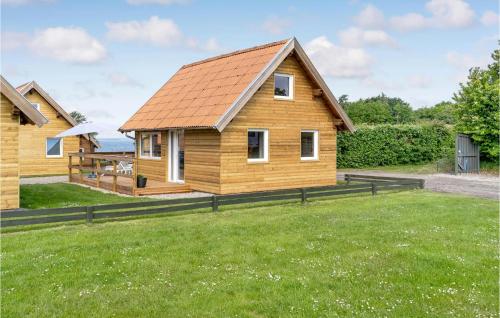 a wooden house with a grassy yard at Gorgeous Home In Tranekær in Tranekær