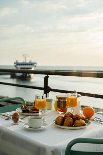 a table with two plates of food and orange juice at Grand Hôtel de Bretagne in Le Palais