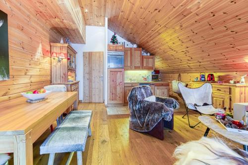 une cuisine avec une table et des chaises dans une pièce dans l'établissement Homency - Résidence Le Kirlys, à L'Alpe-d'Huez