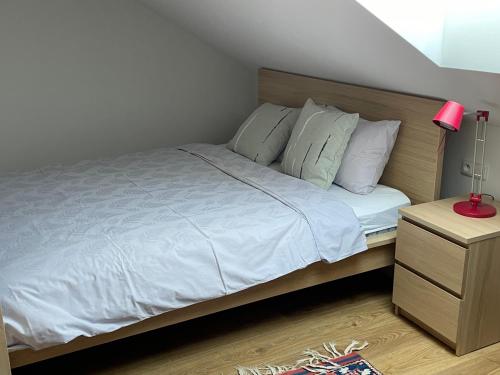 a bedroom with a bed with white sheets and pillows at Apartmán na úpatí Šumavy in Stachy