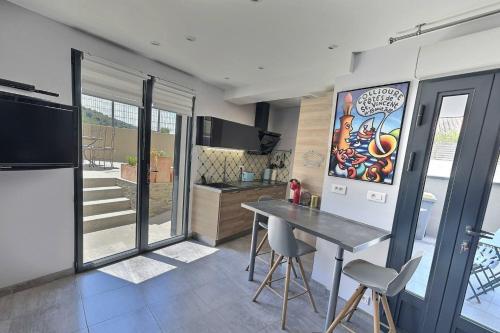 une cuisine avec une table et des chaises dans une pièce dans l'établissement Entre Banyuls et Collioure T2 à Port vendres, à Port-Vendres