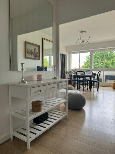 une commode blanche dans un salon avec salle à manger dans l'établissement Appart' La Rochelle, parking & terrasse, 4 pers, à La Rochelle