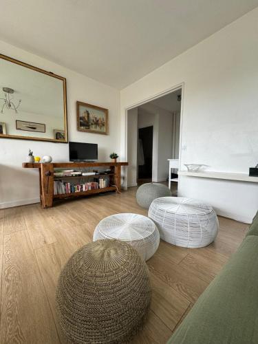 un salon avec deux poufs et deux tables dans l'établissement Appart' La Rochelle, parking & terrasse, 4 pers, à La Rochelle