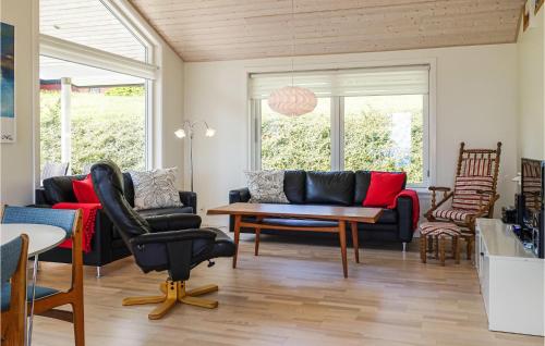 a living room with couches and a table and chairs at Stunning Home In Allinge in Allinge