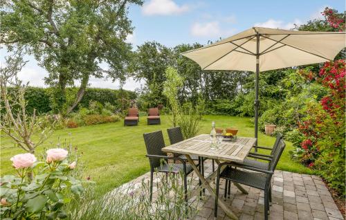 a table with an umbrella in a garden at Gorgeous Home In Sydals With Wifi in Østerby