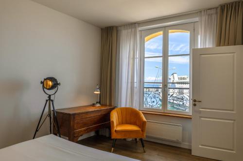 - une chambre avec un bureau, une chaise et une fenêtre dans l'établissement Grand Hôtel de Bretagne, au Palais
