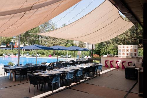 a restaurant with tables and chairs and a pool at Hyatt Regency Bishkek in Bishkek