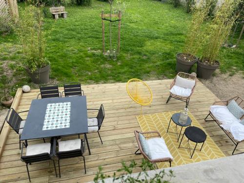 a table and chairs on a wooden deck at La Thibaude - Maison Vigneronne à Charly (proche Lyon) in Charly