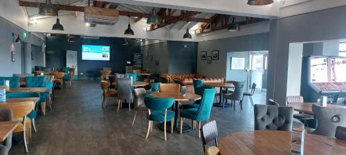 a restaurant with tables and chairs in a room at Bude Coastal Lodge in Bude