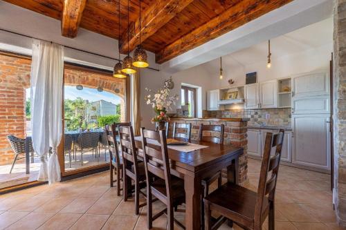 a kitchen with a wooden table and chairs at Ferienhaus in Butkovići mit Privatem Pool in Butkovići