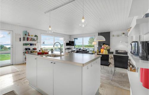a kitchen with white cabinets and a kitchen island at Amazing Home In Roslev With Wifi in Roslev