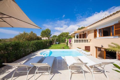 a villa with a swimming pool and patio furniture at Villa Pasero Platon - 300 Meter vom Strand Cala Anguila entfernt in Porto Cristo