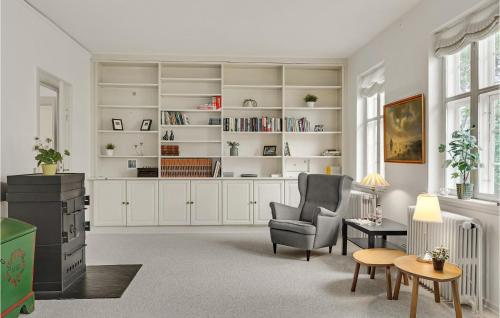 a living room with a chair and a book shelf at Stunning Home In Kværndrup With Wifi in Kværndrup