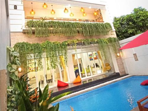 a hotel with a swimming pool in front of a building at Villa Omah Ayu Mendiro in Ngemplak