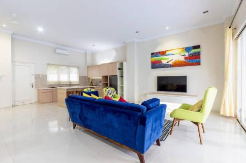 a living room with a blue couch and a kitchen at Villa Omah Ayu Mendiro in Ngemplak