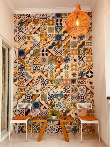 a room with two chairs and a wall covered in tiles at Villa Omah Ayu Mendiro in Ngemplak