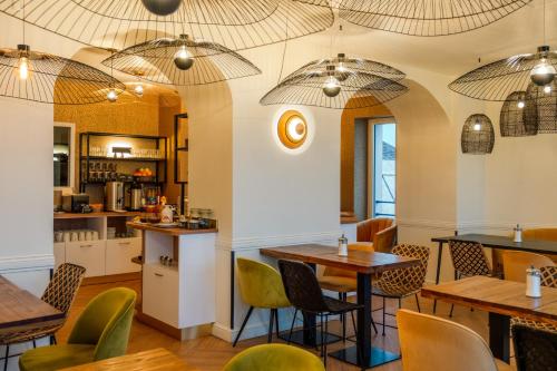 a restaurant with tables and chairs and umbrellas at Grand Hôtel de Bretagne in Le Palais