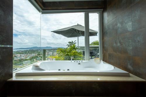 a bath tub in front of a window with an umbrella at Villa Beyond-Namaste 16 Bedroom Fully Staffed Seaview Villa in Ban Thalat Choeng Thale
