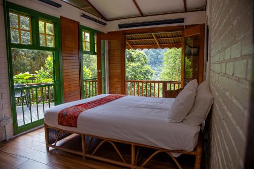 a bedroom with a bed on a balcony with windows at The Dusun in Seremban