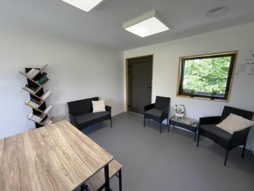 - une salle d'attente avec des chaises, une table et une fenêtre dans l'établissement Camping du Lion d'Angers, à Le Lion-dʼAngers