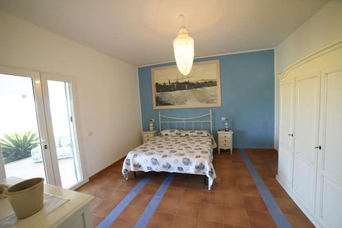 カルロフォルテにあるTramonto sul mare a Carloforteのベッドと壁に絵が飾られた寝室