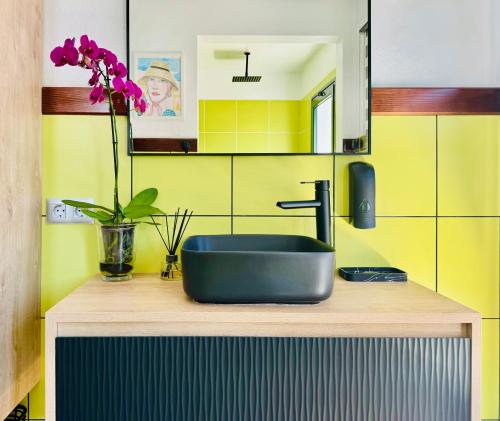 a bathroom with a sink and a flower on a counter at Canaryislandshost I Viñedos in Uga