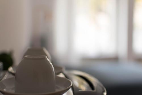 a white cup and saucer on a table at Studio Altbau in Weimar