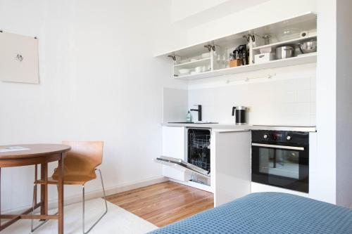 eine kleine weiße Küche mit einem Tisch und einer Theke in der Unterkunft Studio Altbau in Weimar