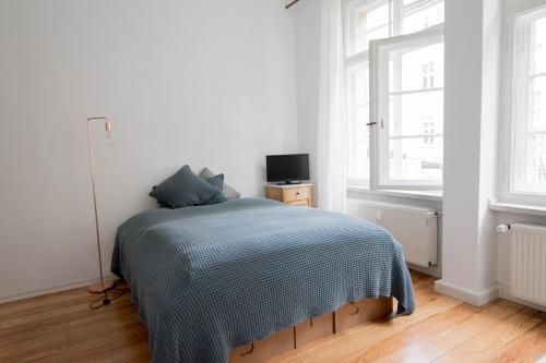 a white bedroom with a bed and a window at Studio Altbau in Weimar