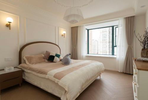 ein Schlafzimmer mit einem Bett, auf dem eine Katze sitzt in der Unterkunft EHUB - City View Apt in Xintiandi Area with French Design Spacious 3Bedroom in Shanghai