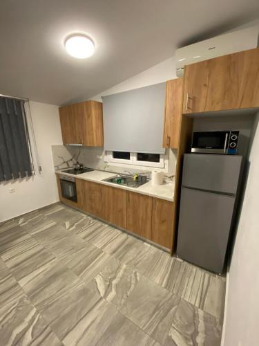 a kitchen with wooden cabinets and a refrigerator at Four Seasons in Leptokaria