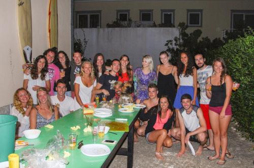 a group of people posing for a picture at a party at Carcavelos Surf Hostel & Surf Camp in Carcavelos