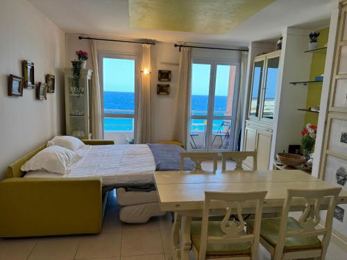 une chambre avec un lit, une table et des fenêtres dans l'établissement VUE mer 02 chambres 45M et parking, à Nice