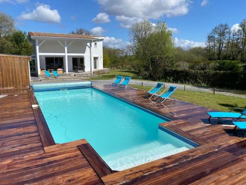 une piscine avec des chaises et une maison dans l'établissement Villa Giulianna le Teich bassin d Arcachon, au Teich