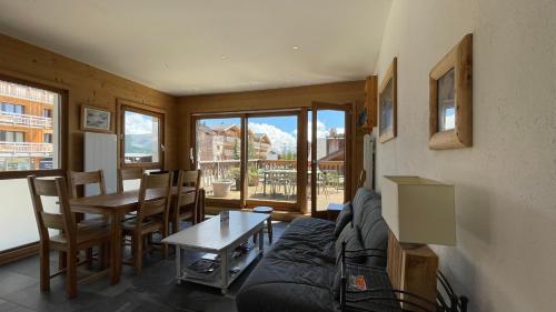 un salon avec un canapé et une table dans l'établissement Homency - Résidence Ménandière W1, à L'Alpe-d'Huez
