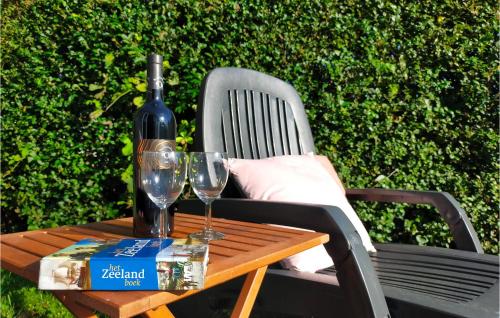 a bottle of wine sitting on a table with two wine glasses at 4 Bedroom Cozy Home In Heinkenszand in Heinkensand