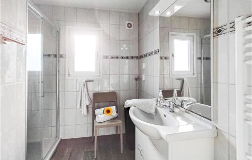 a white bathroom with a sink and a shower at 4 Bedroom Cozy Home In Heinkenszand in Heinkensand