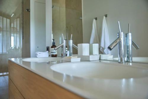 une salle de bain avec un lavabo blanc et un miroir dans l'établissement Havre de paix, à Grézillac