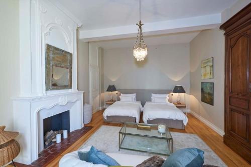 - un salon avec deux lits et une cheminée dans l'établissement Havre de paix, à Grézillac