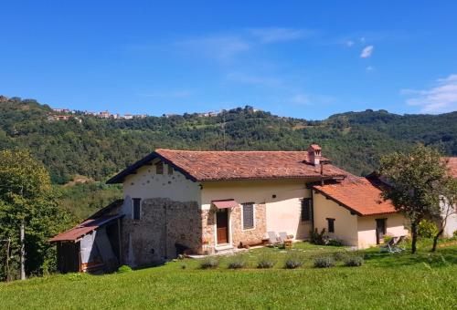 an old house in a field with mountains in the background at La Botalla Agriturismo in Viola