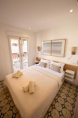 a bedroom with a large bed with towels on it at Casas349h Alicante City Centre Trafalgar in Alicante