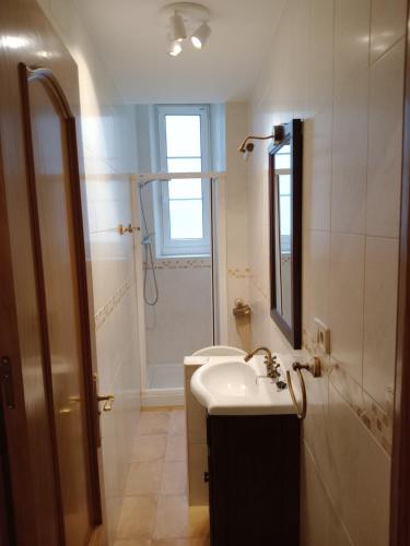 une salle de bain blanche avec un lavabo et une douche dans l'établissement Spacieux T4 Cœur de ville, à Hendaye